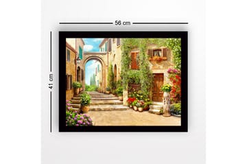 Innrammet lerretsbilde i tre - 41x56 cm - Sjarmerende smug med blomsterprydede hus og en bue i bakgrunnen - Grønn / Gul / Rosa - Interiør - Maleri & posters - Lerretsbilder