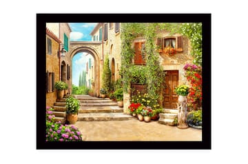 Innrammet lerretsbilde i tre - 41x56 cm - Sjarmerende smug med blomsterprydede hus og en bue i bakgrunnen - Grønn / Gul / Rosa - Interiør - Maleri & posters - Lerretsbilder