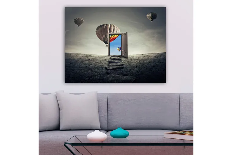 Lerretsbilde 70x100 cm - Åpen dør som fører til en fargerik himmel med varmluftsballonger som svever over et goldt landskap, Grå / Beige / Rød