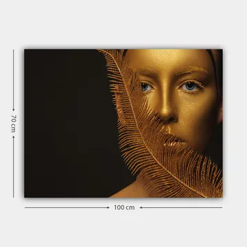 Lerretsbilde 70x100 cm - Ansiktsportrett med gyllen overflate og blå øyne, omgitt av en dekorativ fjærlignende struktur - Gull / Blå - Interiør - Maleri & posters - Lerretsbilder