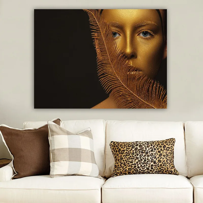 Lerretsbilde 70x100 cm - Ansiktsportrett med gyllen overflate og blå øyne, omgitt av en dekorativ fjærlignende struktur, Gull / Blå