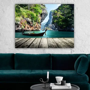 Lerretsbilde 70x100 cm - Båten ligger stille på en steinete strand omgitt av frodige fjell og klart vann - Grønn / Blå / Brun - Interiør - Maleri & posters - Lerretsbilder