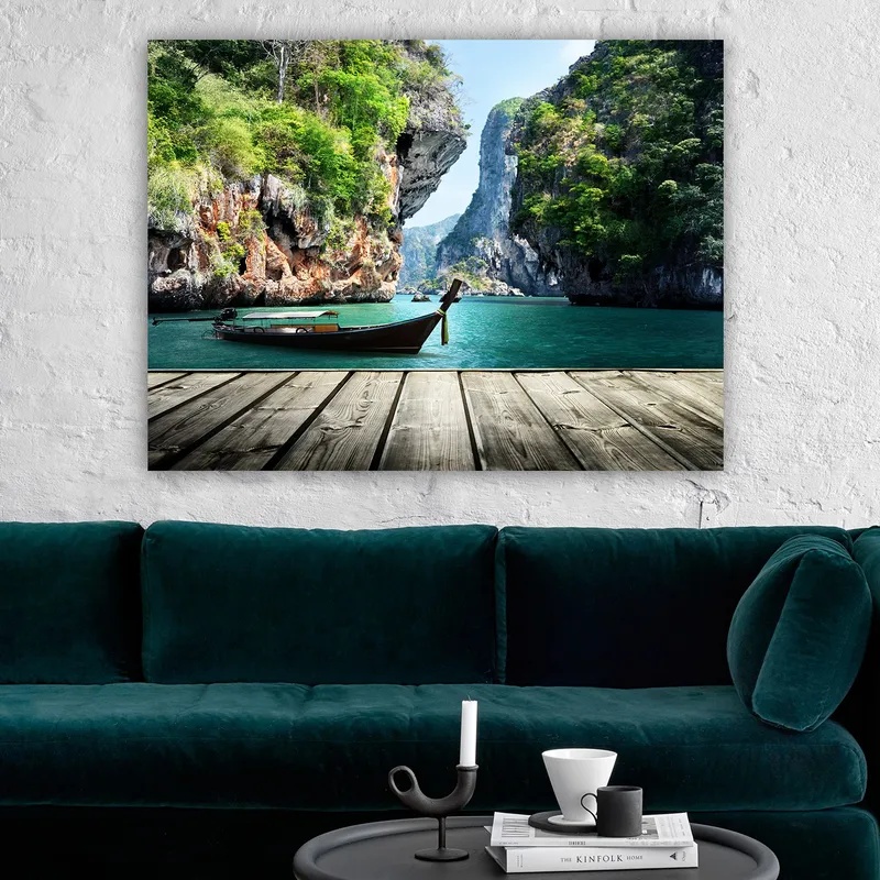 Lerretsbilde 70x100 cm - Båten ligger stille på en steinete strand omgitt av frodige fjell og klart vann - Grønn / Blå / Brun - Interiør - Maleri & posters - Lerretsbilder