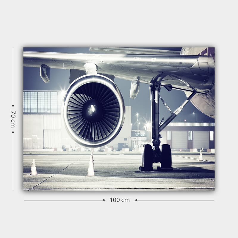 Lerretsbilde 70x100 cm - Detaljert visning av en flymotor og understellet på en flyplass - Grå / Svart / Sølv - Interiør - Maleri & posters - Lerretsbilder