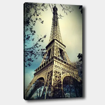 Lerretsbilde 70x100 cm - Eiffeltårnet i Paris, fotografert fra lav vinkel med omkringliggende tregrener - Grå / Beige / Blå - Interiør - Maleri & posters - Lerretsbilder