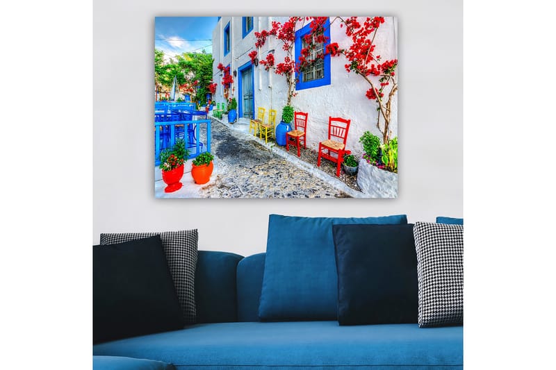 Lerretsbilde 70x100 cm - Fargerik gate med blomster og stoler i forskjellige farger som skaper en livlig atmosfære - Blå / Rød / Grønn - Interiør - Maleri & posters - Lerretsbilder