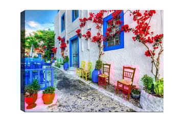 Lerretsbilde 70x100 cm - Fargerik gate med blomster og stoler i forskjellige farger som skaper en livlig atmosfære - Blå / Rød / Grønn - Interiør - Maleri & posters - Lerretsbilder