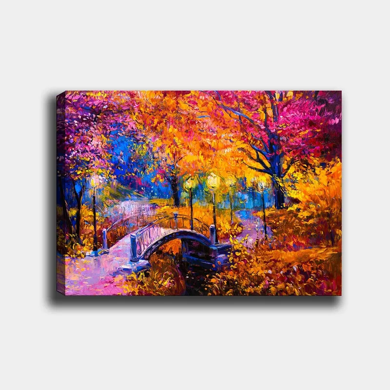 Lerretsbilde 70x100 cm - Fargerik høstscene med en bro som spenner over en stille vannflate, omgitt av trær i varme høstfarger, Oransje / Lilla / Gul