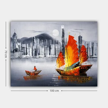 Lerretsbilde 70x100 cm - Fargerik seilbåt med røde seil på en speilblank vannflate, omgitt av et moderne bybilde - Rød / Oransje / Blå - Interiør - Maleri & posters - Lerretsbilder