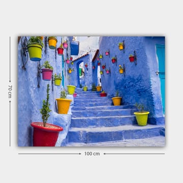 Lerretsbilde 70x100 cm - Fargerik trapp omgitt av blomsterpotter i et pittoresk, blått bymiljø - Blå / Gul / Rød - Interiør - Maleri & posters - Lerretsbilder