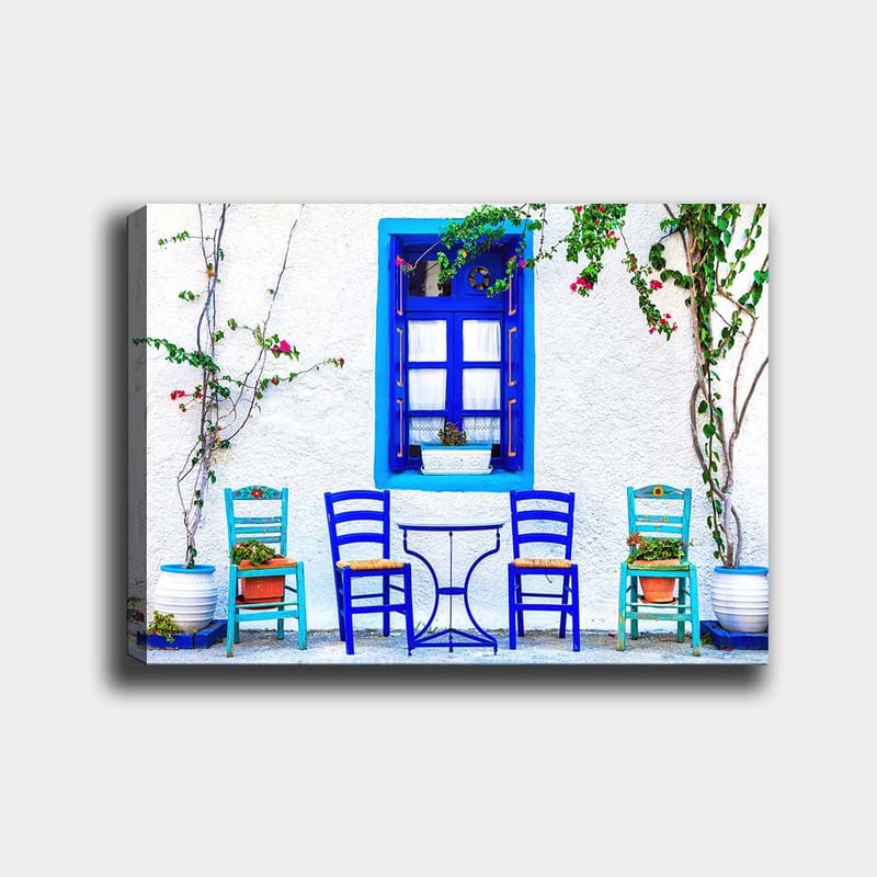 Lerretsbilde 70x100 cm - Fargerik utendørs spiseplass med blå stoler og vinduer i middelhavsmiljø, Blå / Grønn / Hvit