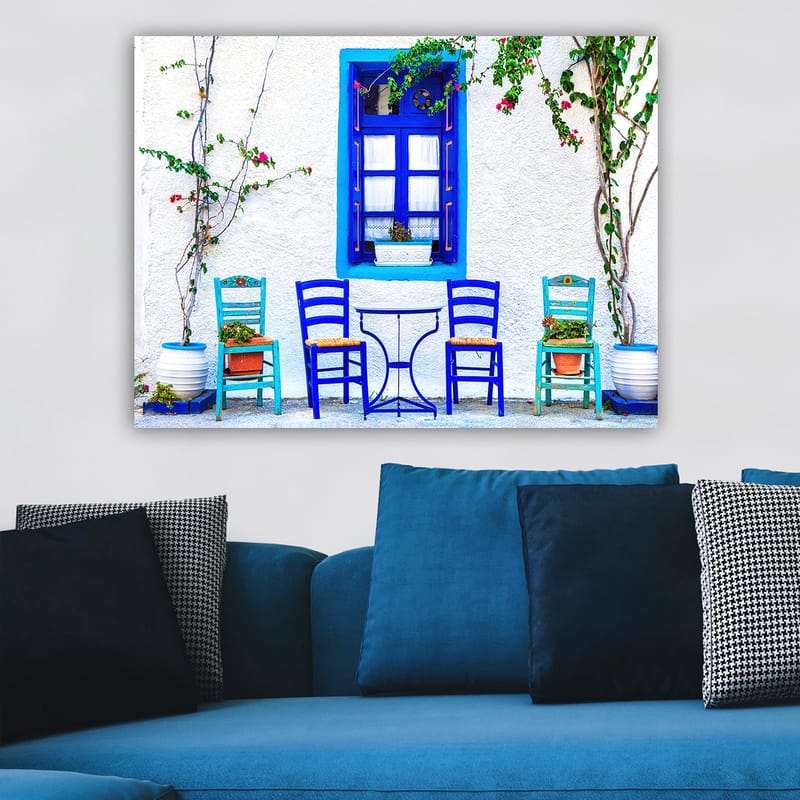 Lerretsbilde 70x100 cm - Fargerik utendørs spiseplass med blå stoler og vinduer i middelhavsmiljø - Blå / Grønn / Hvit - Interiør - Maleri & posters - Lerretsbilder