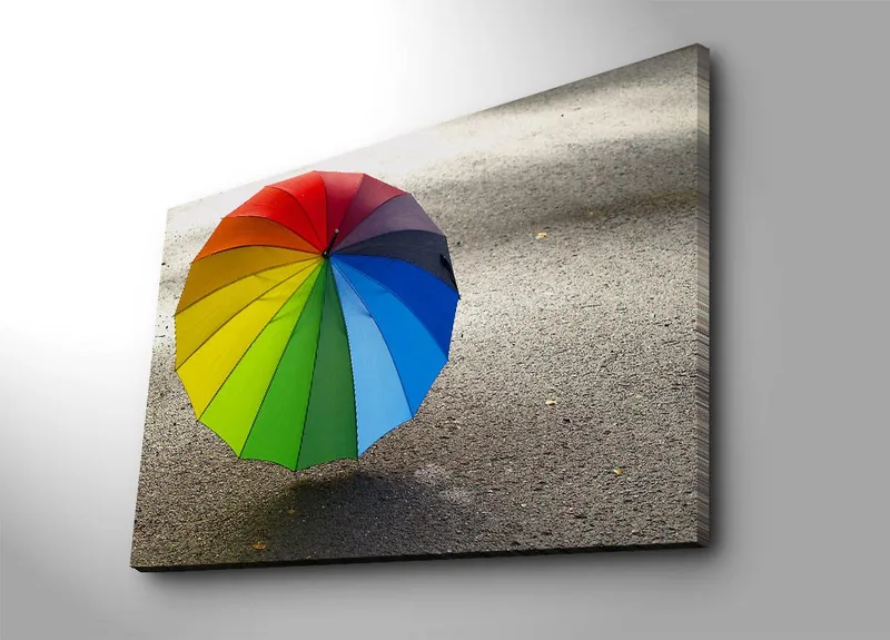 Lerretsbilde 70x100 cm - Fargerik paraply stående på en grå overflate, Rød / Grønn / Blå