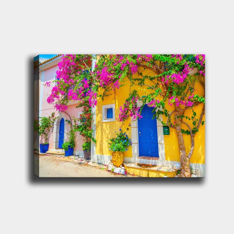 Lerretsbilde 70x100 cm - Fargerike hus med bougainvillea som blomstrer i en travel gate, Blå / Gul / Rosa