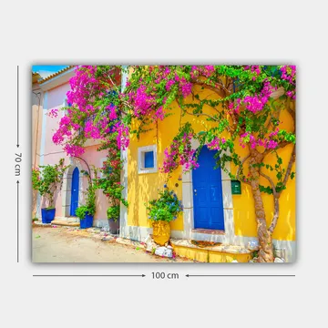 Lerretsbilde 70x100 cm - Fargerike hus med bougainvillea som blomstrer i en travel gate - Blå / Gul / Rosa - Interiør - Maleri & posters - Lerretsbilder