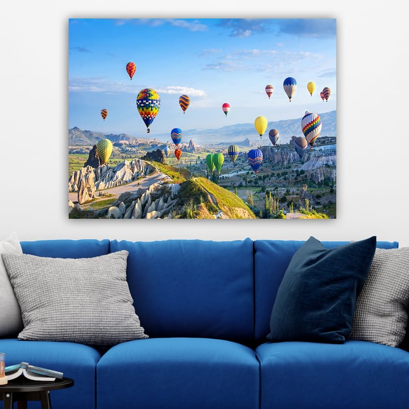 Lerretsbilde 70x100 cm - Fargerike varmluftsballonger svever over et vakkert landskap i Kappadokia - Grønn / Blå / Gul - Interiør - Maleri & posters - Lerretsbilder