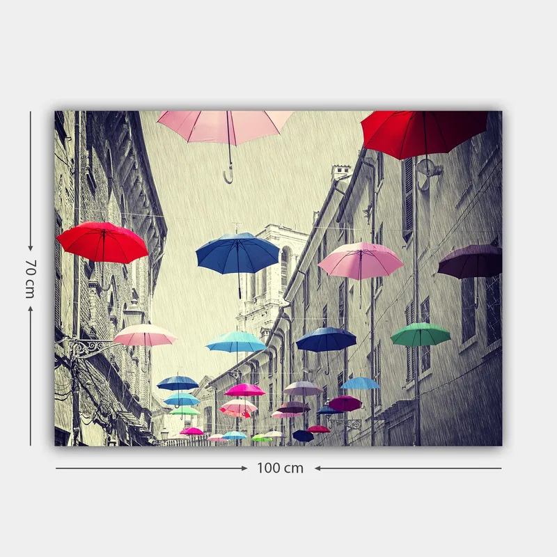 Lerretsbilde 70x100 cm - Fargerike paraplyer svever over en grå bygate - Rød / Blå / Rosa - Interiør - Maleri & posters - Lerretsbilder