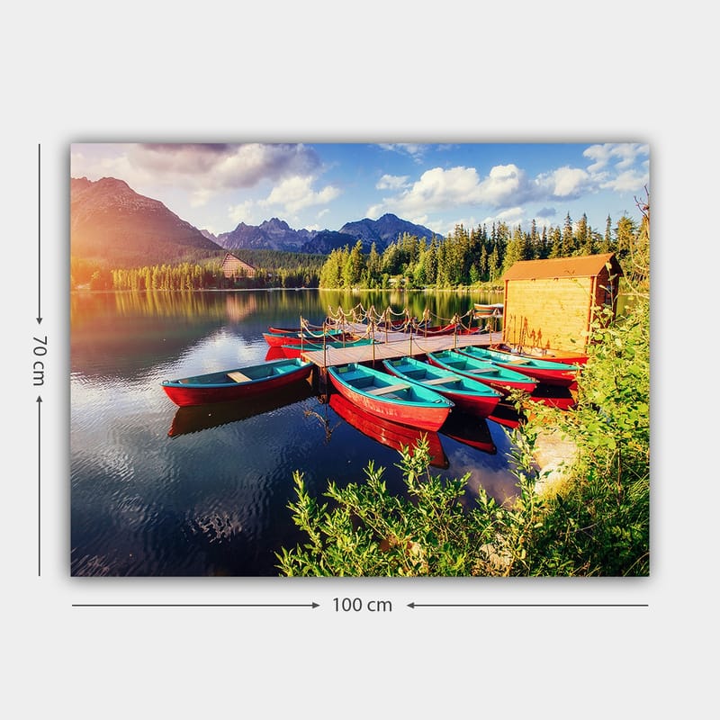 Lerretsbilde 70x100 cm - Flere fargerike båter ligger på en speilblank innsjø omgitt av frodige trær og fjell - Rød / Turkis / Grønn - Interiør - Maleri & posters - Lerretsbilder
