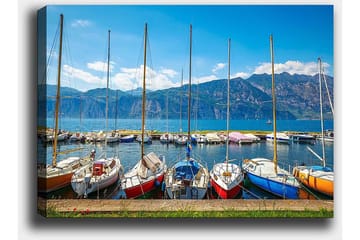 Lerretsbilde 70x100 cm - Flere fargerike seilbåter i en havn med fjell i bakgrunnen - Blå / Rød / Oransje - Interiør - Maleri & posters - Lerretsbilder