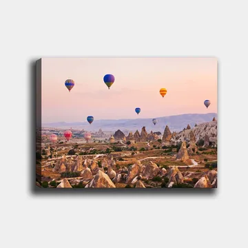 Lerretsbilde 70x100 cm - Flere fargerike varmluftsballonger svever over et dramatisk landskap med unike fjellformasjoner - Blå / Rød / Oransje - Interiør - Maleri & posters - Lerretsbilder