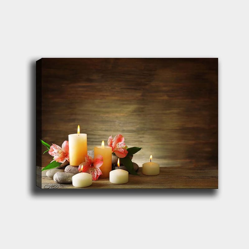 Lerretsbilde 70x100 cm - Fredelig komposisjon av skinnende lys og rosa blomster på steiner, Lys gul / Rosa / Grønn