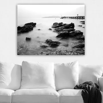 Lerretsbilde 70x100 cm - Fredelig kystlandskap med klipper og en brygge i det fjerne - Svart / Hvit / Grå - Interiør - Maleri & posters - Lerretsbilder