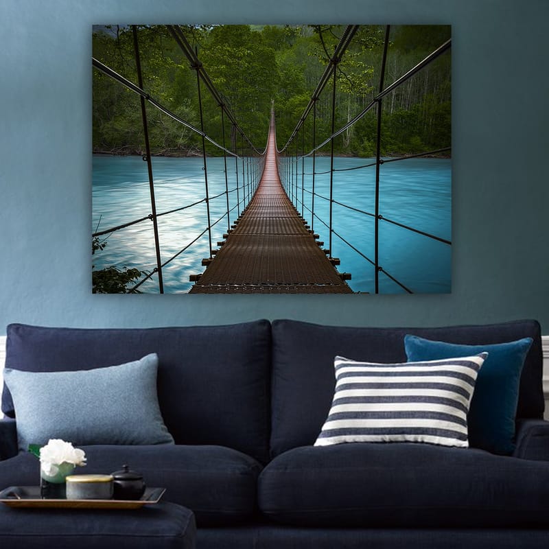 Lerretsbilde 70x100 cm - Hengebro som går over en rolig, blå elv omgitt av frodige trær - Mørk brun / Turkis / Grønn - Interiør - Maleri & posters - Lerretsbilder