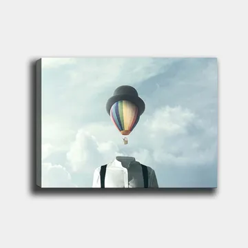 Lerretsbilde 70x100 cm - Hodeløs mann i hvit skjorte og svart hatt, med en fargerik varmluftsballong som svever over seg - Hvit / Svart / Regnbue - Interiør - Maleri & posters - Lerretsbilder