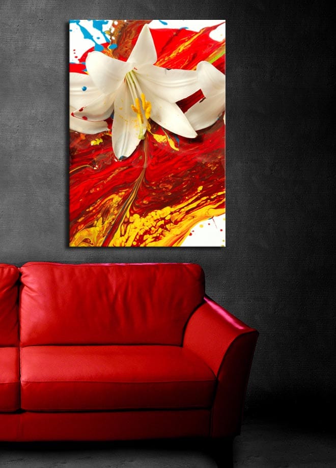 Lerretsbilde 70x100 cm - Hvit lilje som står frem mot en bakgrunn av intense røde og gule farger - Rød / Gul / Hvit - Interiør - Maleri & posters - Lerretsbilder