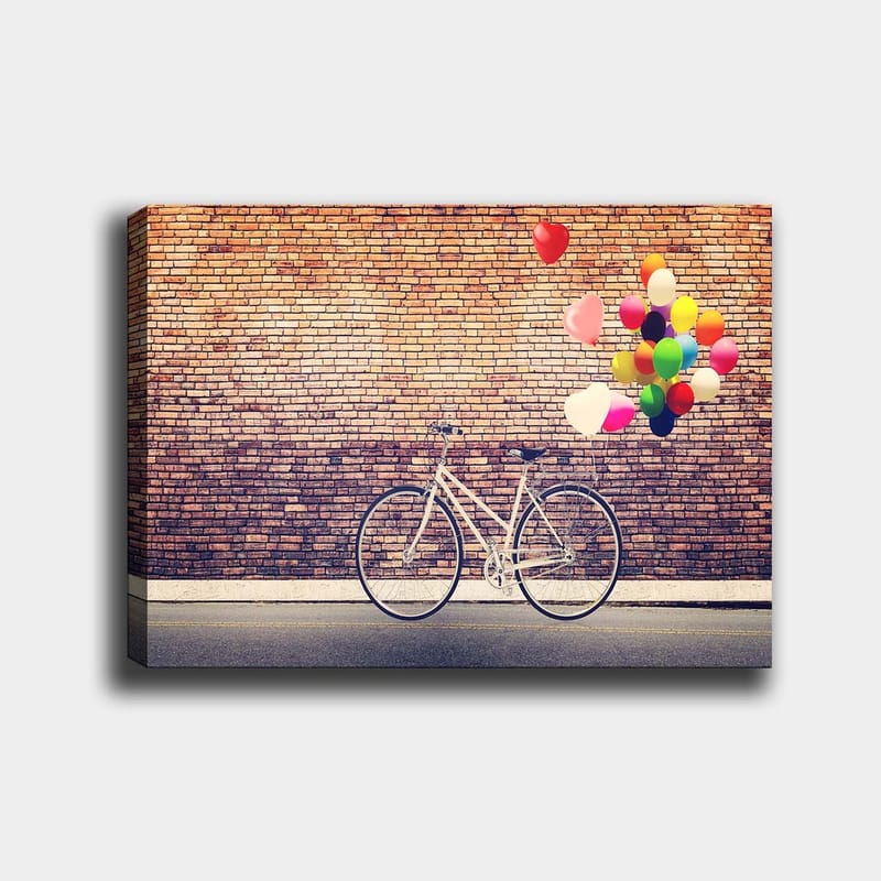 Lerretsbilde 70x100 cm - Hvit sykkel med fargerike ballonger som svever over mot en murvegg, Hvit / Rød / Gul