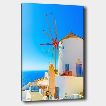 Lerretsbilde 70x100 cm - Hvit vindmølle med rød rotor på en klippe ved havet, omgitt av klar blå himmel og hav - Hvit / Rød / Blå - Interiør - Maleri & posters - Lerretsbilder