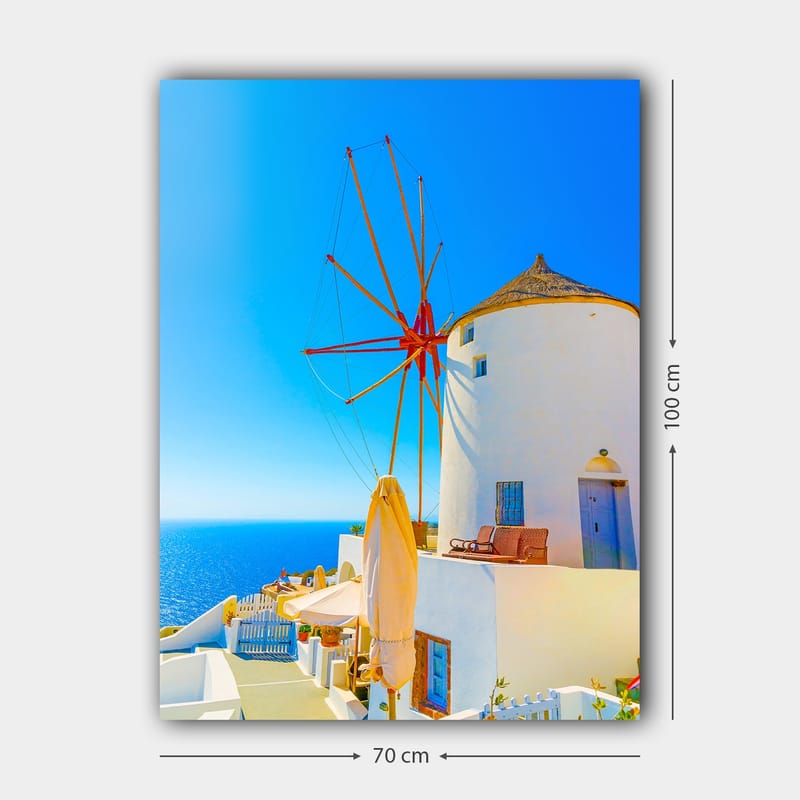 Lerretsbilde 70x100 cm - Hvit vindmølle med rød rotor på en klippe ved havet, omgitt av klar blå himmel og hav - Hvit / Rød / Blå - Interiør - Maleri & posters - Lerretsbilder