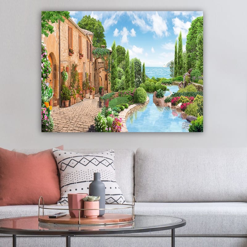 Lerretsbilde 70x100 cm - Idyllisk landsby med blomster, trær og en glitrende innsjø i bakgrunnen - Grønn / Blå / Terrakotta - Interiør - Maleri & posters - Lerretsbilder