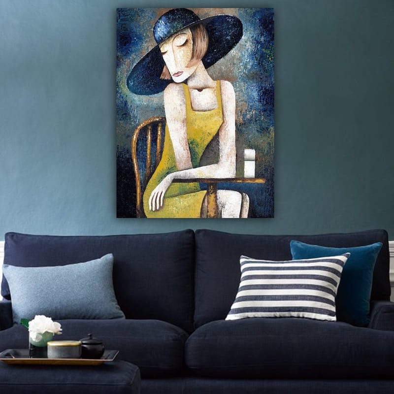 Lerretsbilde 70x100 cm - Kvinne i gul kjole sitter ved et bord med en hvit kopp, iført en stor svart hatt - Gul / Svart / Blågrønn - Interiør - Maleri & posters - Lerretsbilder