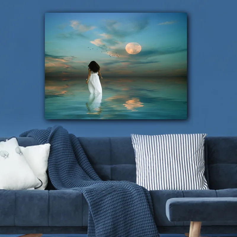 Lerretsbilde 70x100 cm - Kvinne i hvit kjole går gjennom et speilblankt hav under en stjernehimmel med en stor måne - Blå / Hvit / Grå - Interiør - Maleri & posters - Lerretsbilder