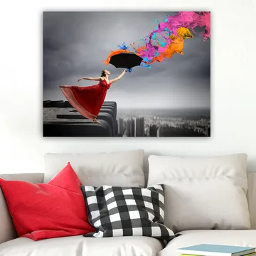 Lerretsbilde 70x100 cm - Kvinne i rød kjole står på en kant og holder en paraply, mens fargerike malingsstråler spruter ut fra den - Rød / Svart / Oransje - Interiør - Maleri & posters - Lerretsbilder