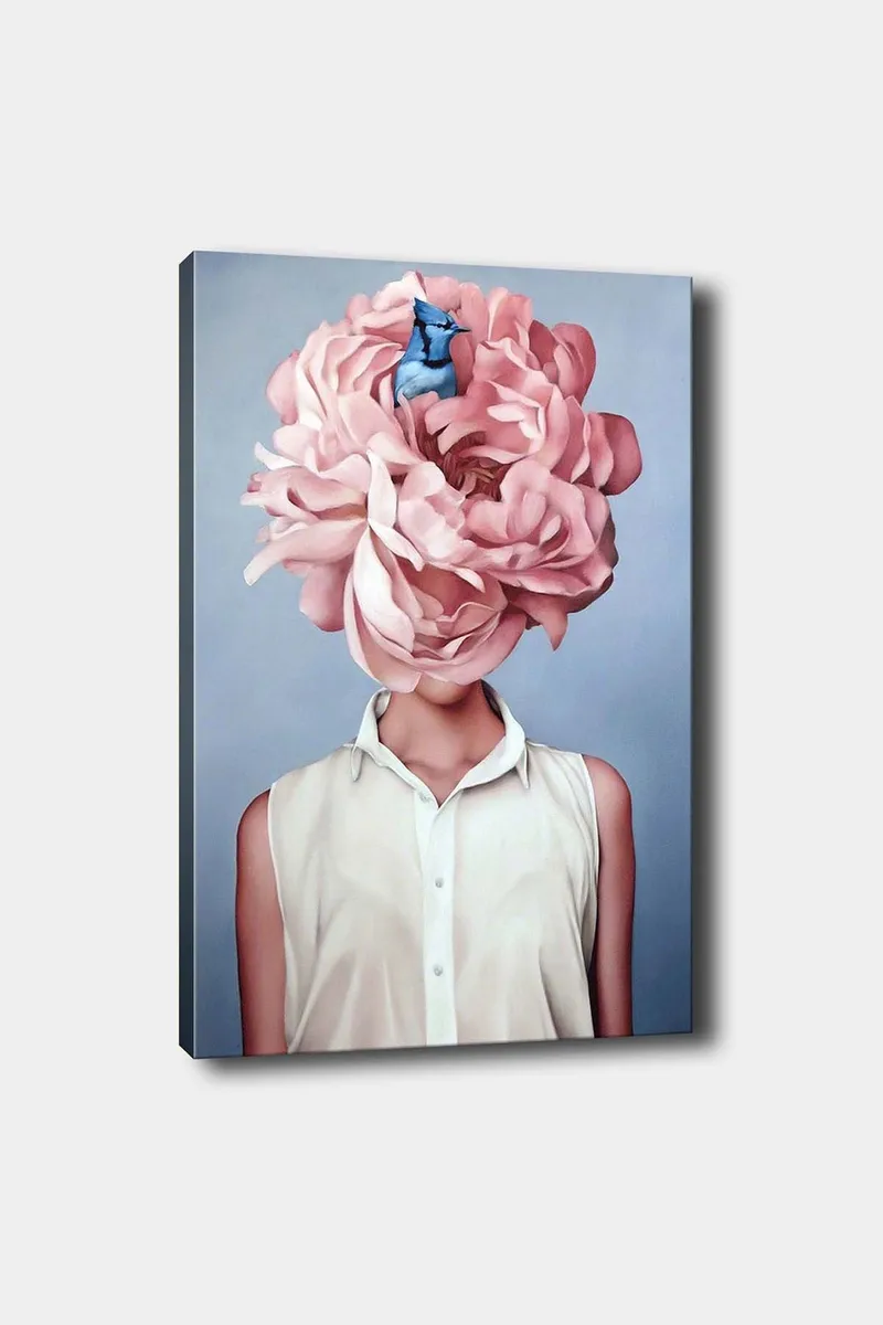 Lerretsbilde 70x100 cm - Kvinne med et stort rosa blomsterhodeplagg og en blå fugl som sitter blant blomstene, Rosa / Blå / Beige