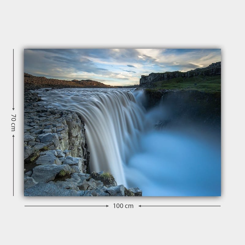 Lerretsbilde 70x100 cm - Majestetisk foss som renner over steiner i naturskjønne omgivelser - Blå / Grå / Hvit - Interiør - Maleri & posters - Lerretsbilder