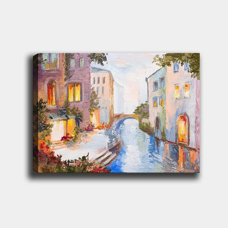 Lerretsbilde 70x100 cm - Malerisk kanal med fargerike hus og en bro som speiler seg i vannet, Lys blå / Lilla / Oransje