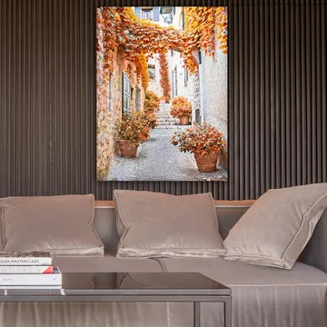 Lerretsbilde 70x100 cm - Malerisk smug omgitt av fargerike høstblader og potteplanter - Oransje / Brun / Gul - Interiør - Maleri & posters - Lerretsbilder