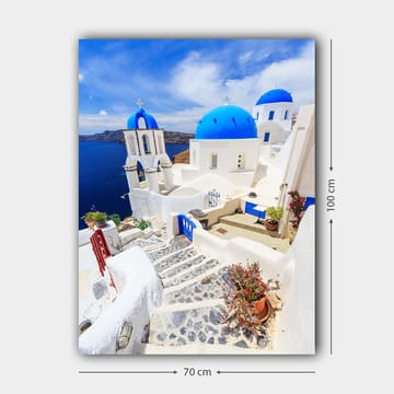 Lerretsbilde 70x100 cm - Malerisk utsikt over hvite hus med blå kupler og en asfaltert vei i en gresk øy-setting - Blå / Hvit - Interiør - Maleri & posters - Lerretsbilder