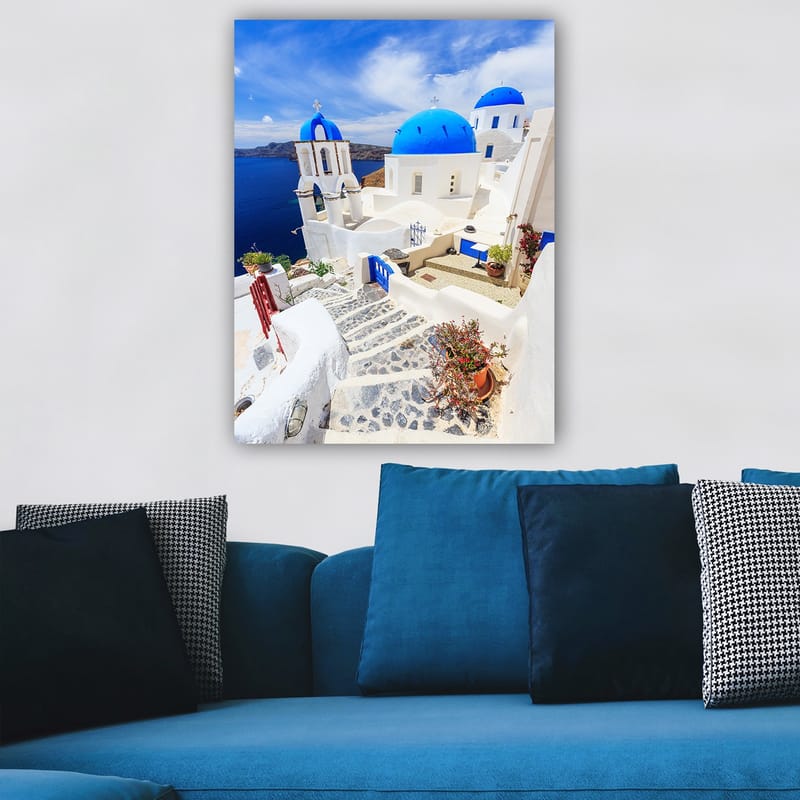 Lerretsbilde 70x100 cm - Malerisk utsikt over hvite hus med blå kupler og en asfaltert vei i en gresk øy-setting - Blå / Hvit - Interiør - Maleri & posters - Lerretsbilder