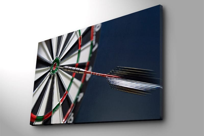 Lerretsbilde 70x100 cm - Nærbilde av en dartskive med en pil som treffer midtpunktet - Grønn / Rød / Svart - Interiør - Maleri & posters - Lerretsbilder