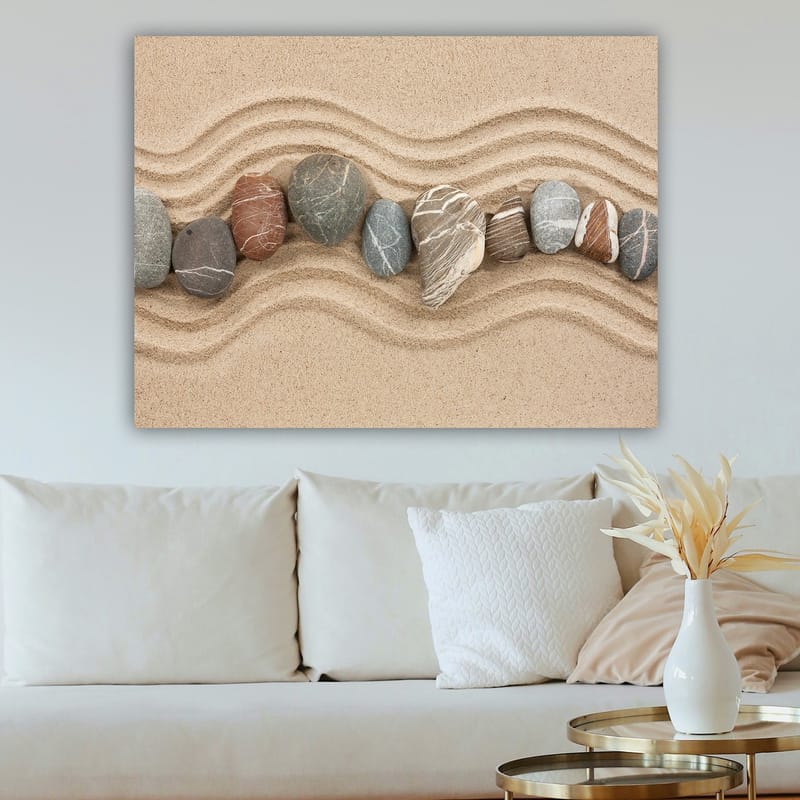 Lerretsbilde 70x100 cm - Rad med glatte steiner plassert på en sandoverflate med bølgete mønstre - Sandbeige / Grå / Rødbrun - Interiør - Maleri & posters - Lerretsbilder