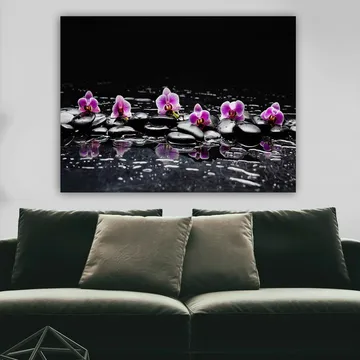 Lerretsbilde 70x100 cm - Rad med lilla orkideer som hviler på svarte steiner med refleksjoner i vann - Lilla / Svart - Interiør - Maleri & posters - Lerretsbilder