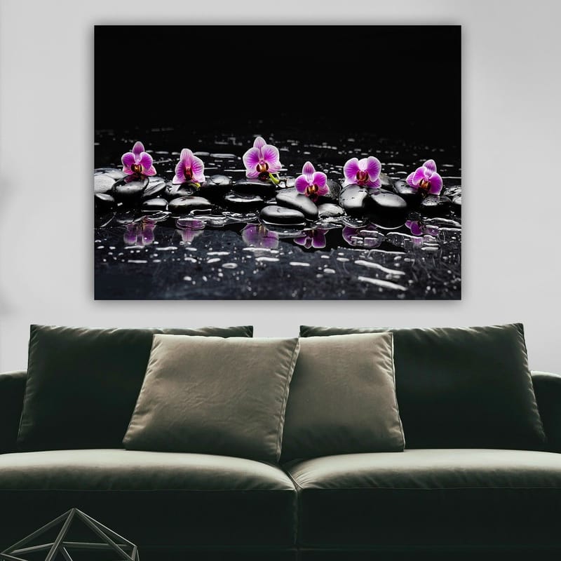 Lerretsbilde 70x100 cm - Rad med lilla orkideer som hviler på svarte steiner med refleksjoner i vann - Lilla / Svart - Interiør - Maleri & posters - Lerretsbilder