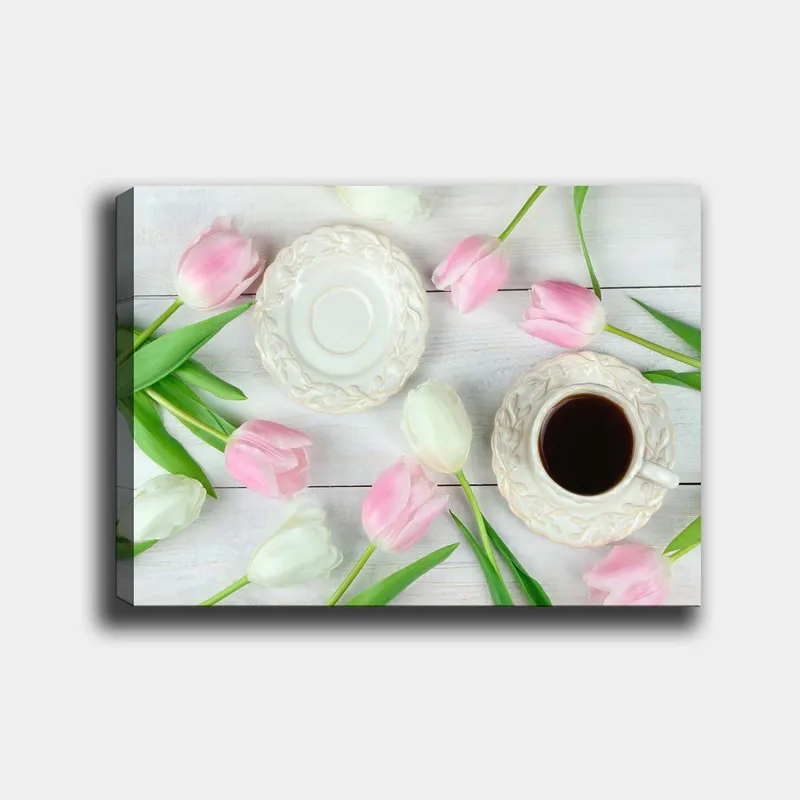 Lerretsbilde 70x100 cm - Rolig borddekking med en kopp kaffe og tulipaner i rosa og hvitt, Rosa / Hvit / Grønn