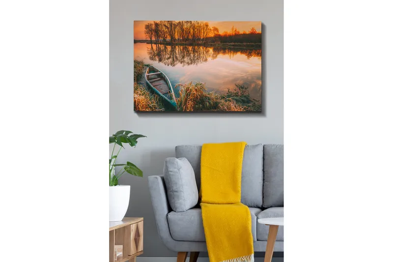 Lerretsbilde 70x100 cm - Rolig innsjø med båt på bredden i en vakker solnedgang, Oransje / Grønn / Brun