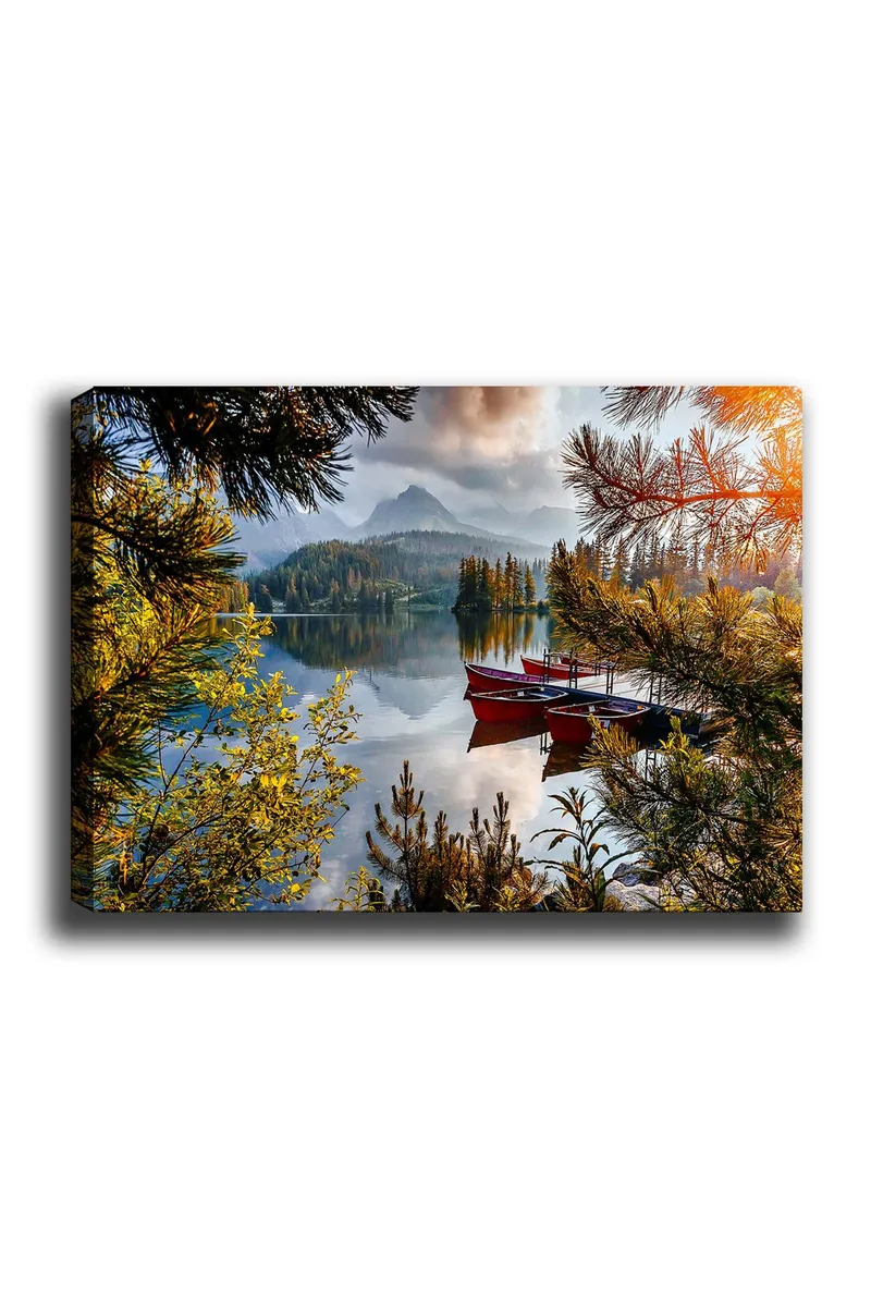 Lerretsbilde 70x100 cm - Rolig innsjø med en rød båt ved en trebrygge, omgitt av frodige trær og fjerne fjell - Grønn / Rød / Blå - Interiør - Maleri & posters - Lerretsbilder