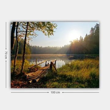 Lerretsbilde 70x100 cm - Rolig innsjø med en trebro omgitt av frodige trær og morgensolens stråler - Grønn / Brun / Gul - Interiør - Maleri & posters - Lerretsbilder